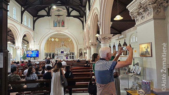 Algimantas Milvydas fotografuoja atminimo lentą bažnyčioje